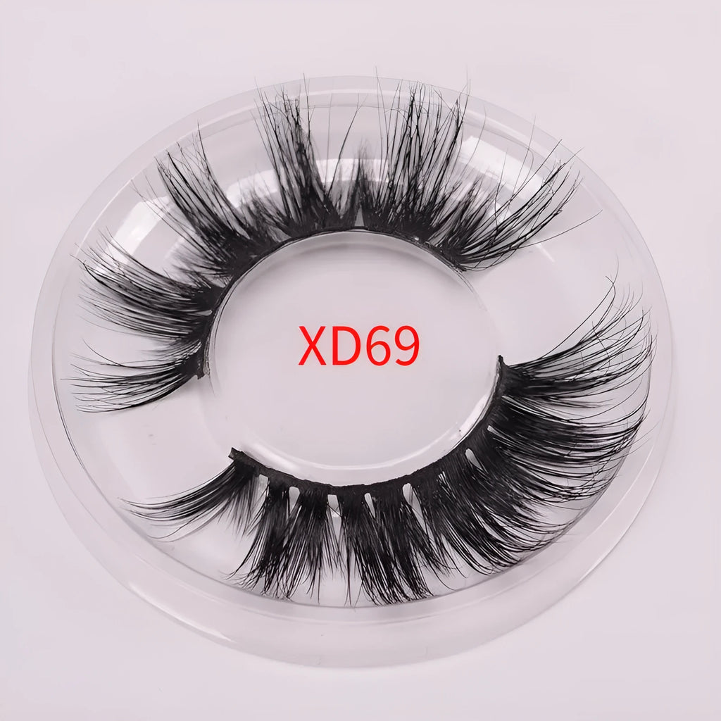 A pair of 5D mink false eyelashes with a hair cap and double-headed brush on a white background.