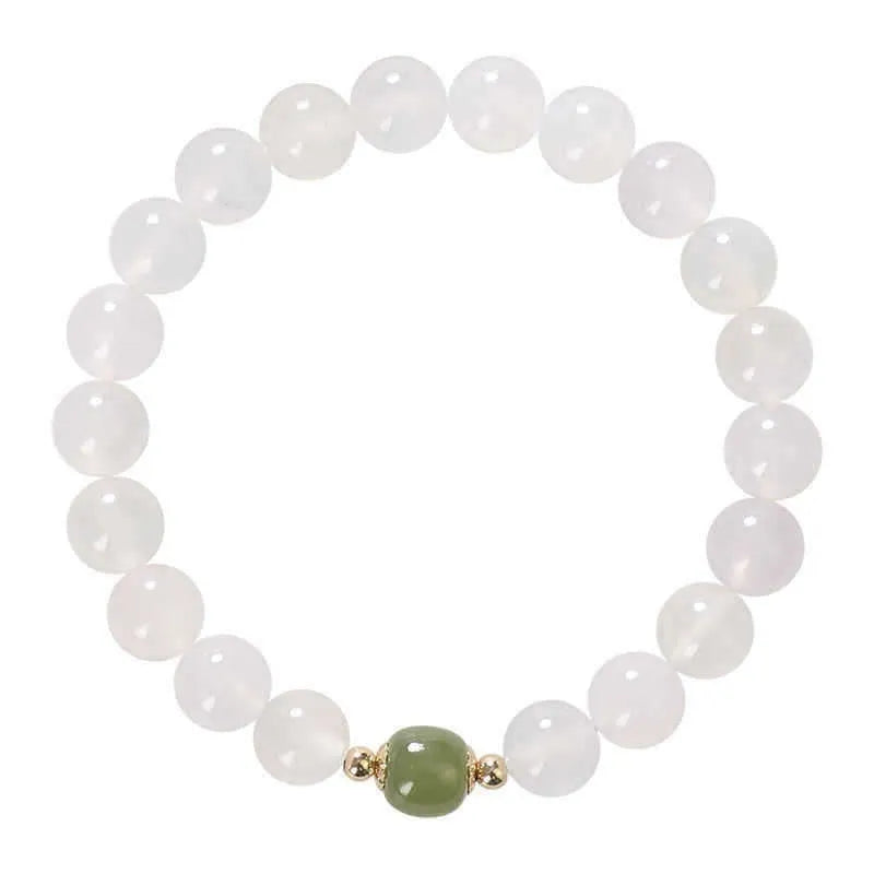 Handmade white agate and Hetian jade crystal bracelet with cinnabar accents on a wrist.