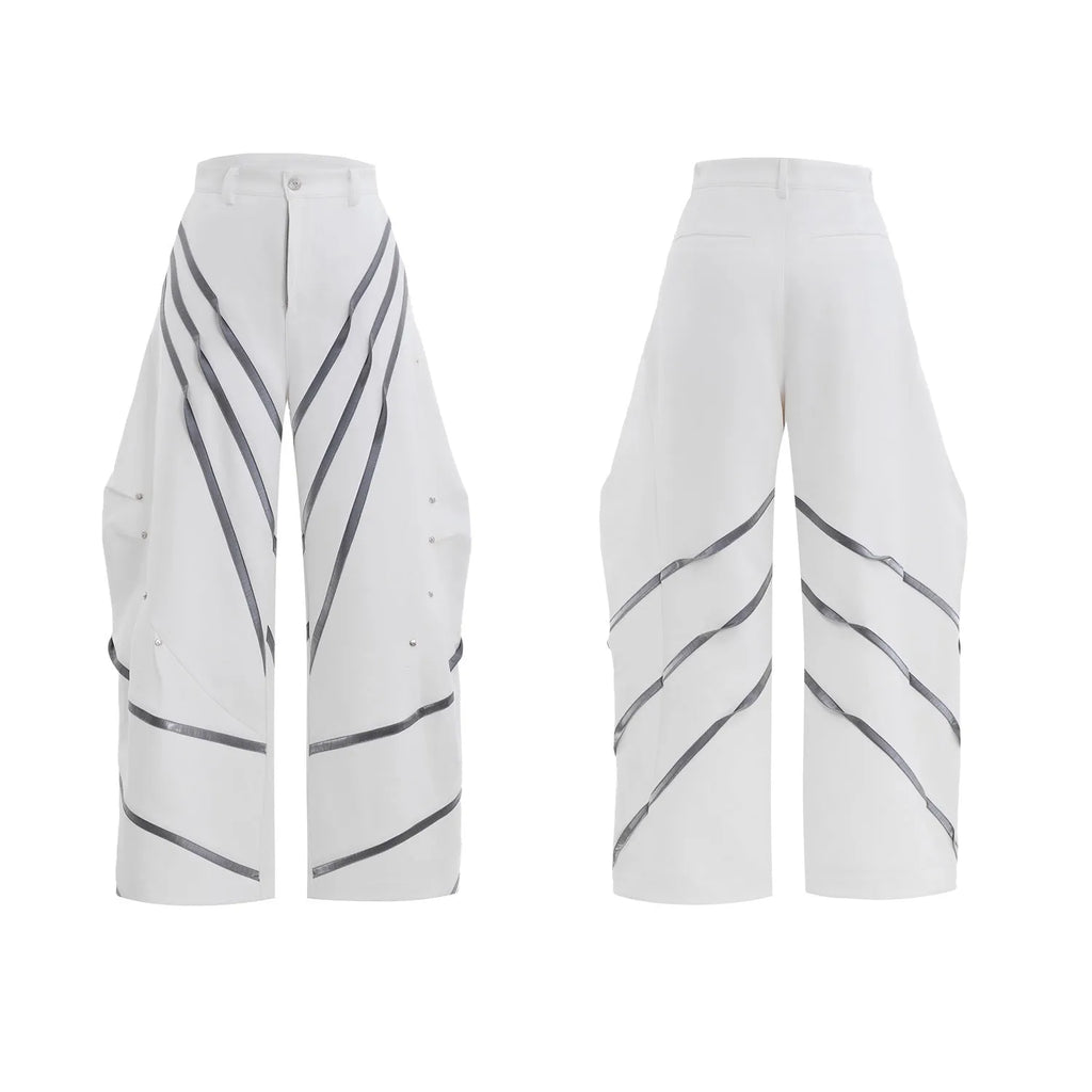 Men's black polyester trousers with metal striped rivets and pleated detail on a white background.