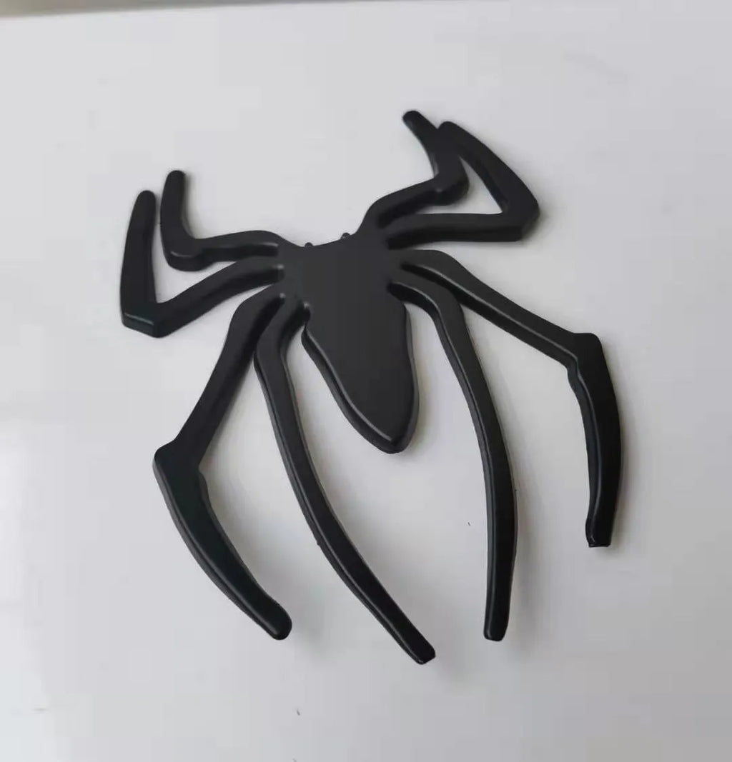 Three-dimensional metal spider car sticker in gold, silver, black, or red.