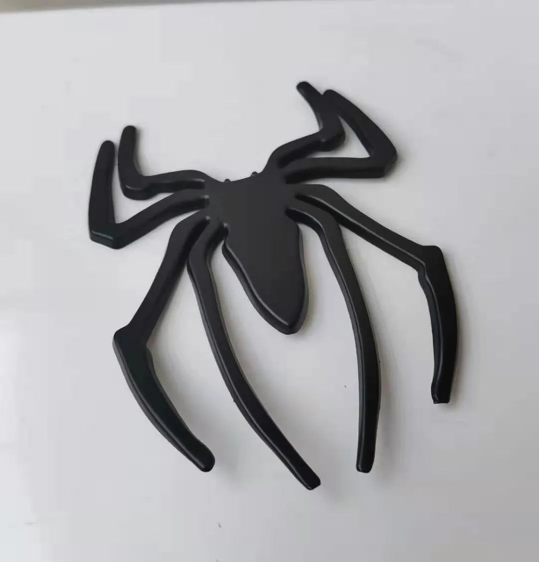 Three-dimensional metal spider car sticker in gold, silver, black, or red.