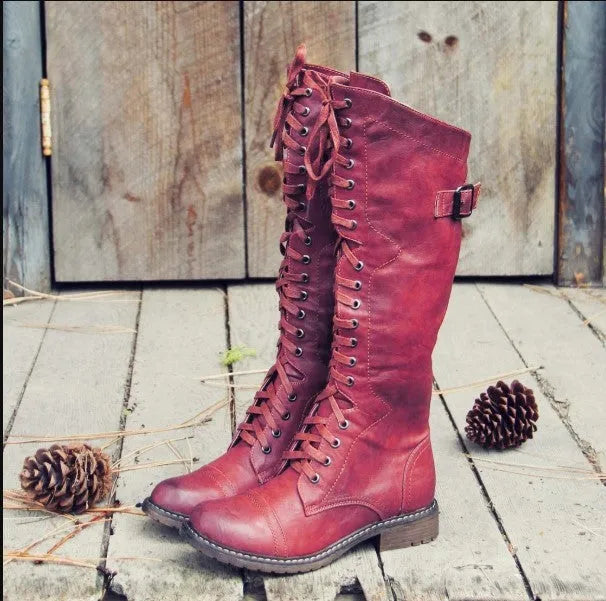 Women's black ankle boot with a cross strap design and zip fastening on the side.