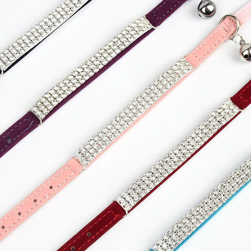 Close-up of a red suede velvet cat collar with rhinestones, showing the adjustable buckle.