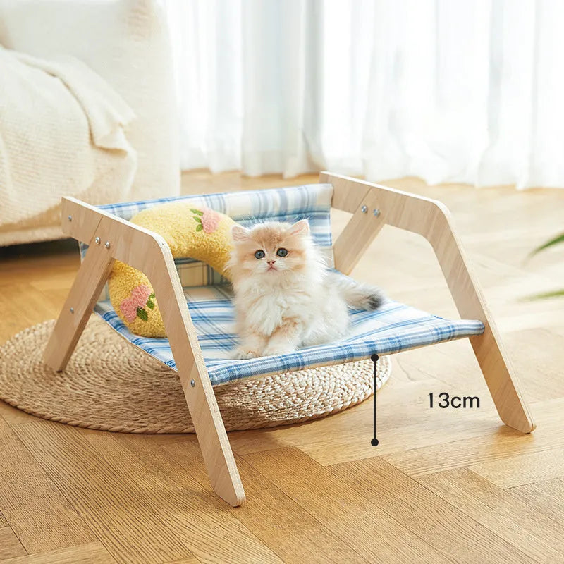 Wooden framed elevated cat bed with blue cloth hammock in beach chair style.