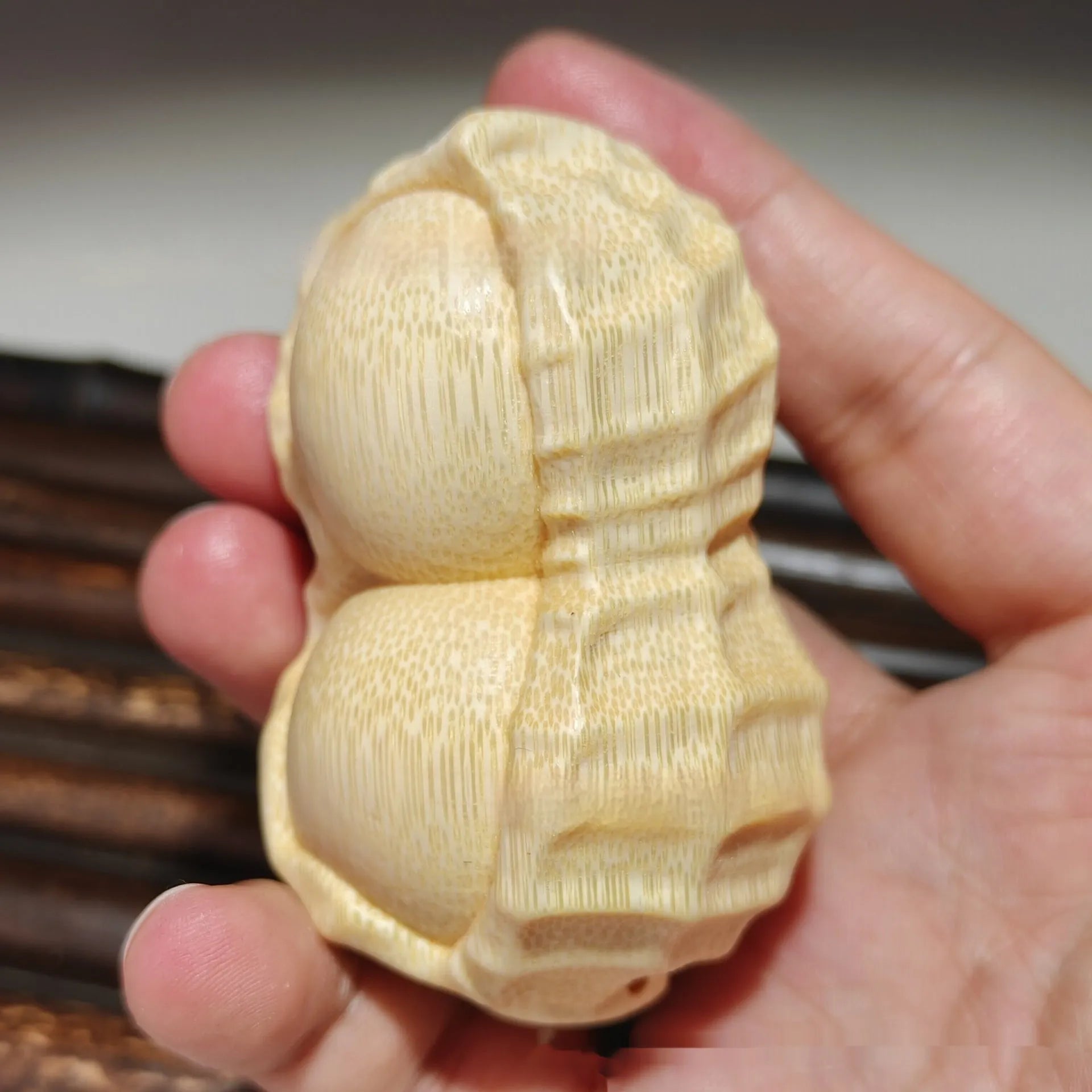Solid bamboo peanut ornament carving on a plain background