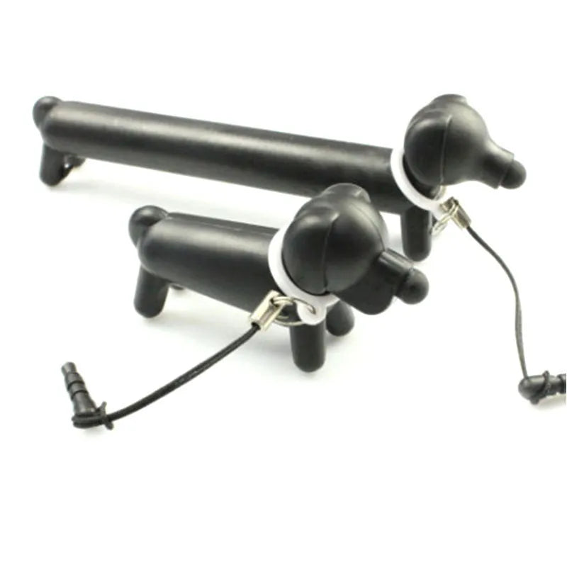Black dog-shaped touch screen stylus pen shown next to a smartphone on a desk.
