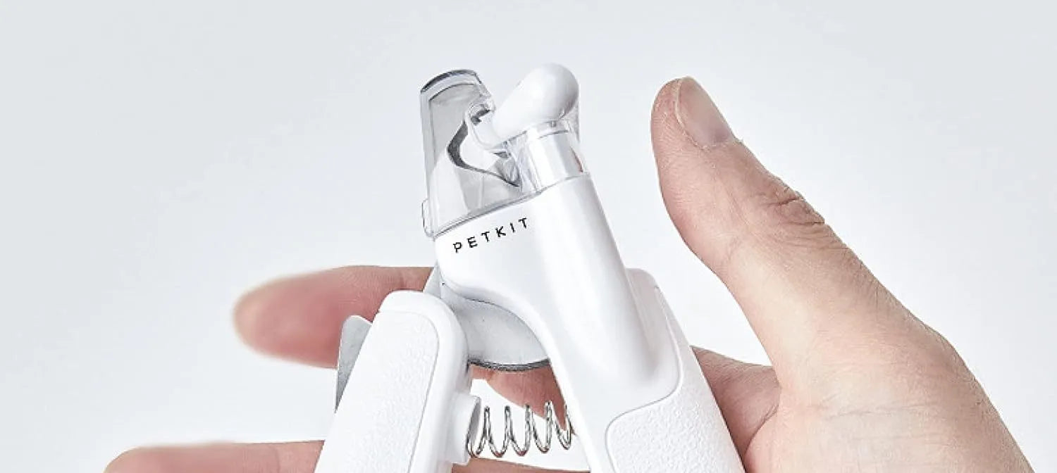 White pet nail clippers with LED light, transparent anti-splash guard, and integrated nail file on a grey background.