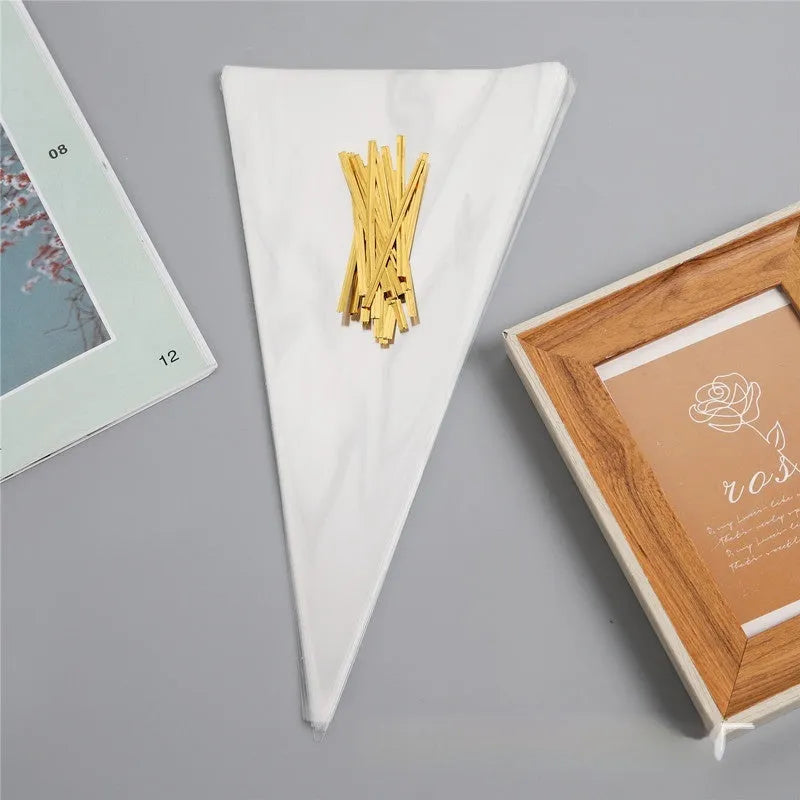 Clear triangle-shaped plastic packaging bags with a twisted wire tie closure on a white background.