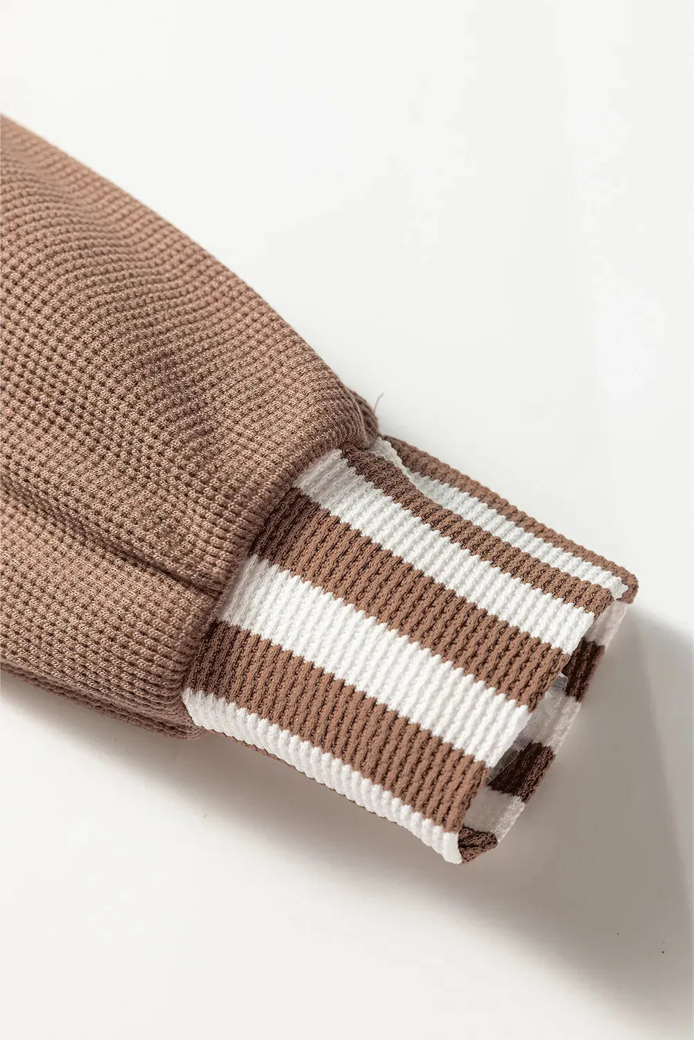 Straw yellow hoodie with waffle texture fabric and striped patchwork panels, featuring a drawstring hood and button neck.