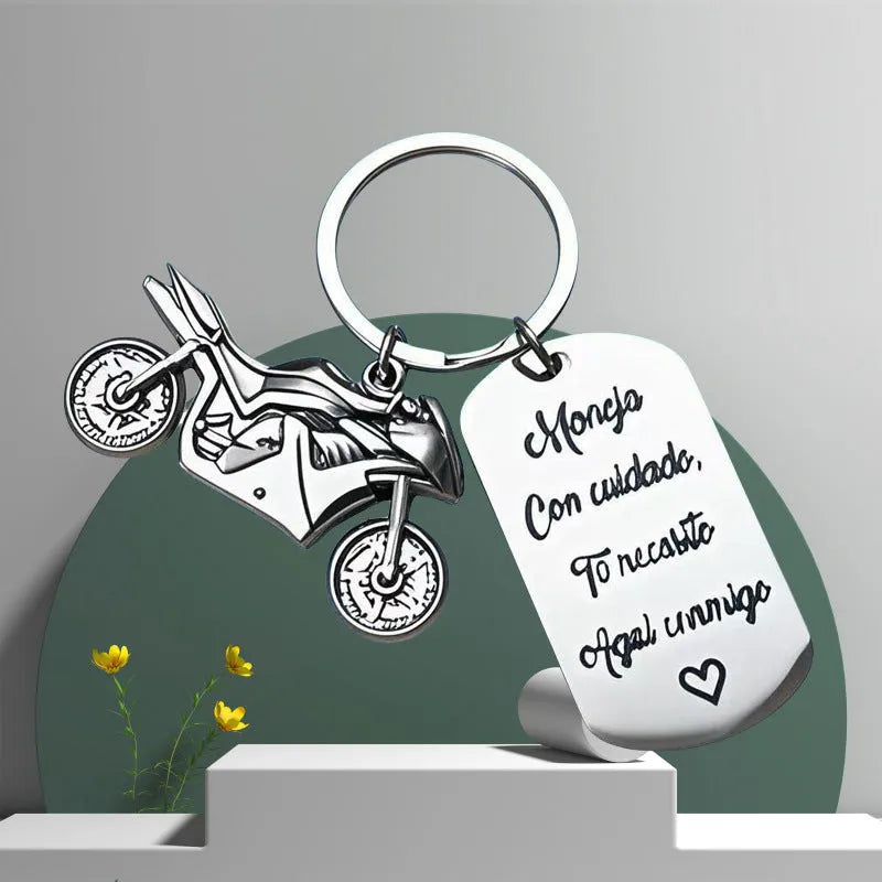 Stainless steel motorcycle key chain with modern design on velvet cloth.