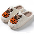 A pair of black and white Halloween-themed plush house slippers with rubber soles.