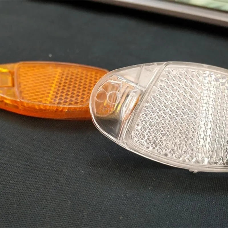White and yellow bicycle spoke reflectors with plastic construction and night warning film