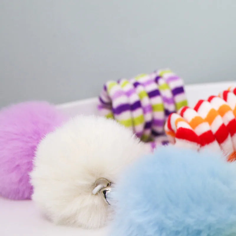 Hanging spring cat toy with bell and inflatable ball attached to window by suction cup