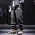 Man wearing grey straight-leg casual sweatpants with an ankle-tied design detail.