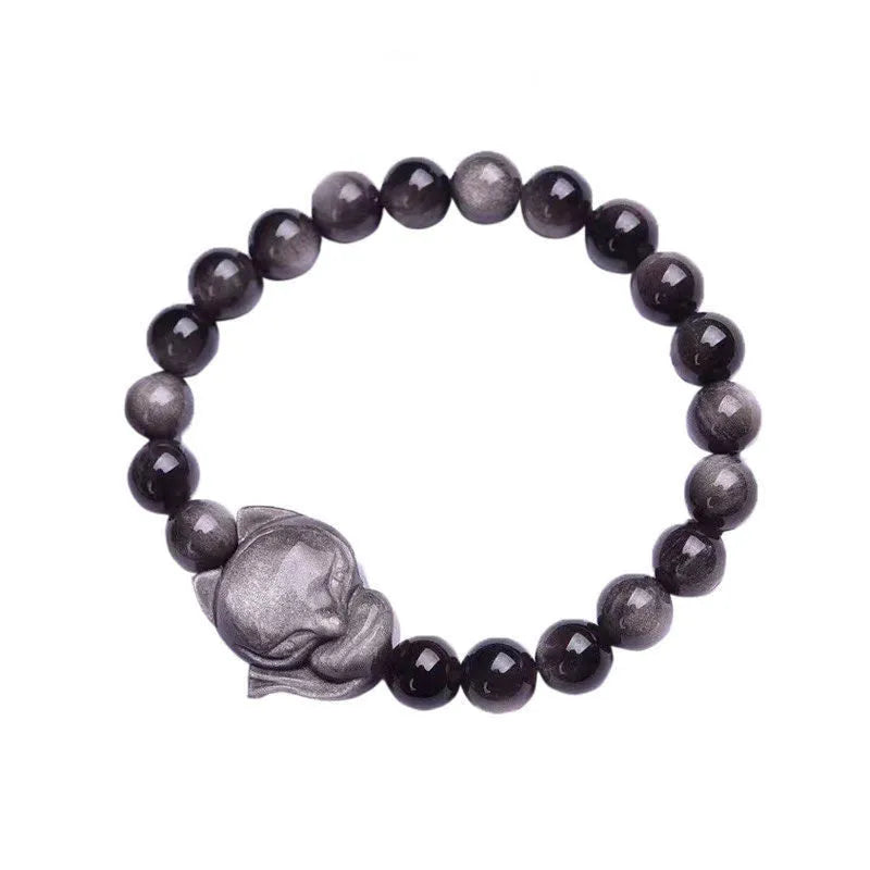 Close-up of a polished black obsidian bracelet bead carved with a detailed fox design.