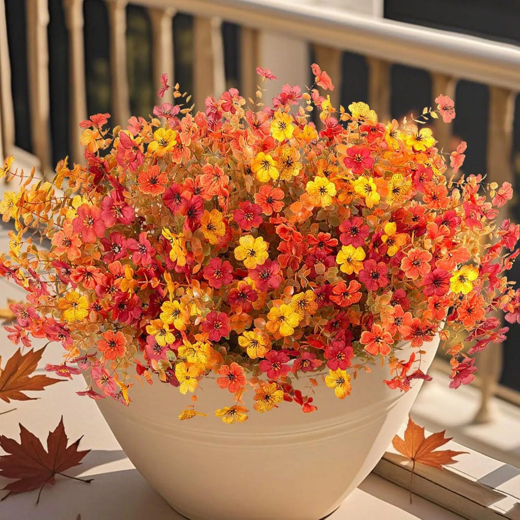 Artificial flower bouquet in autumn colours of red, yellow, orange, and orange yellow for home decoration