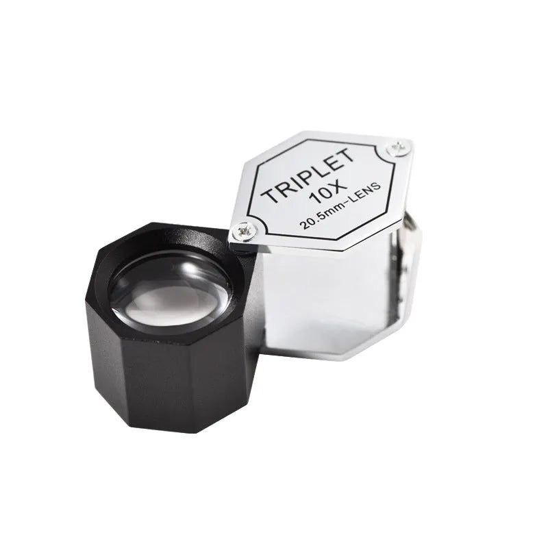 Handheld portable magnifying glass with metal body and optical glass lens for jewellery and coin inspection.