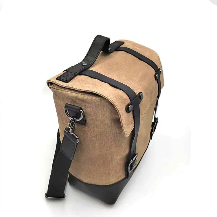 Motorcycle side bag with waterproof canvas construction showing mounting straps and main compartment