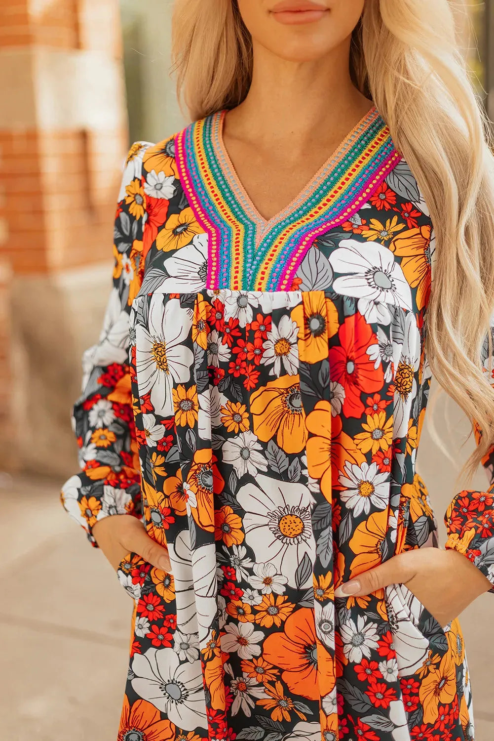 Orange floral stripe bodycon mini dress with V-neck and lace detailing on long sleeves.