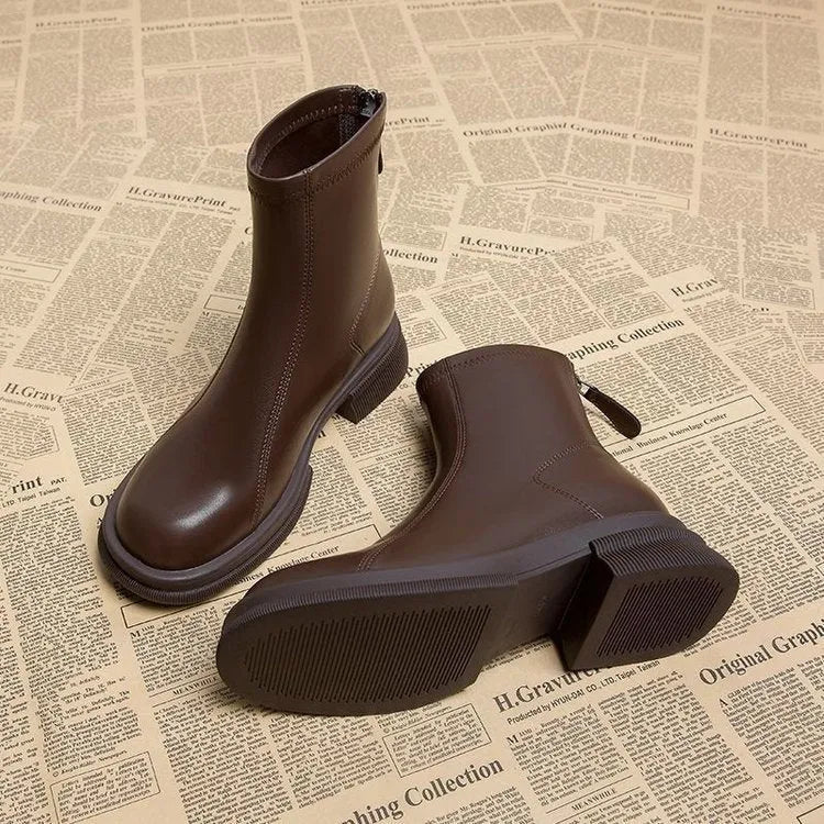 Women's black ankle boots with a flat heel, round toe, and a back zipper.