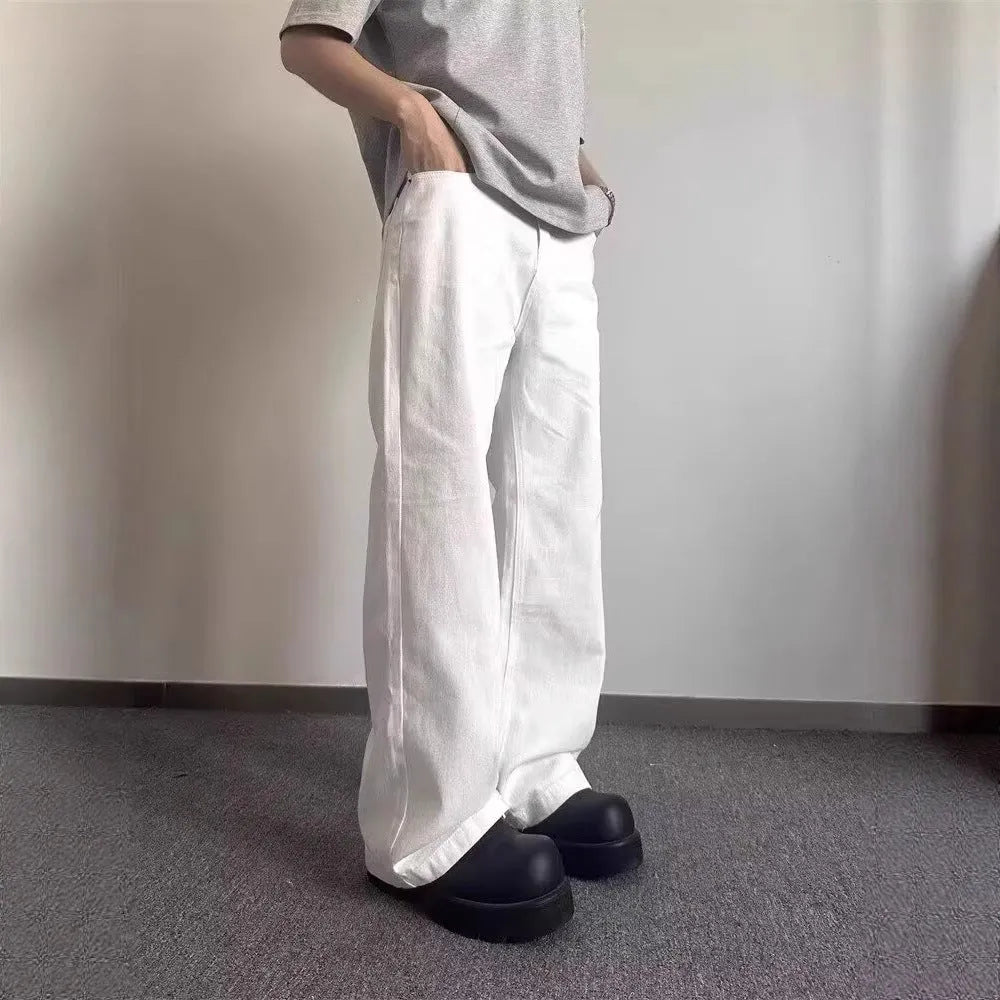 Men's white loose fit straight leg denim jeans on a mid waist with a zipper fly.