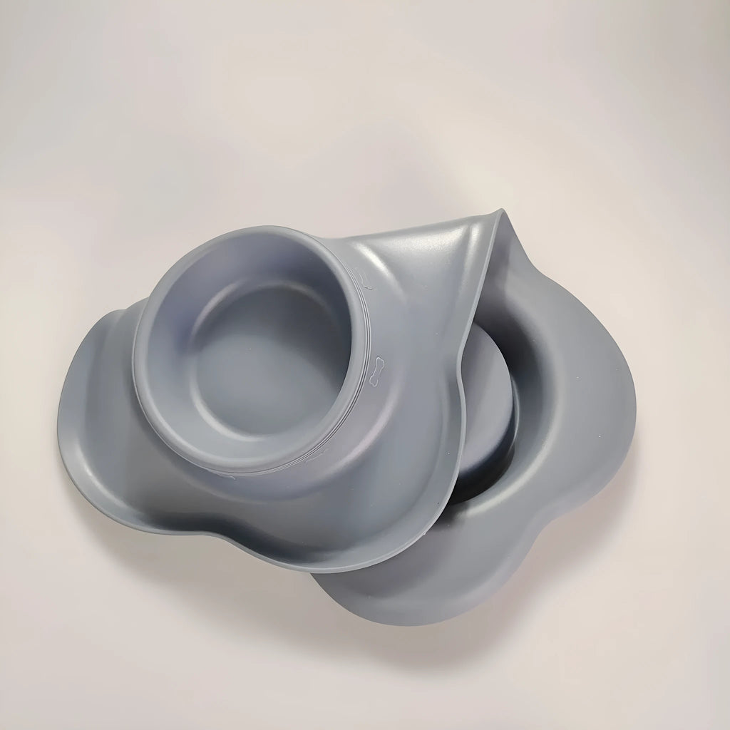 Large silicone dog bowl with a stainless steel inner insert, shown in blue on a floor.