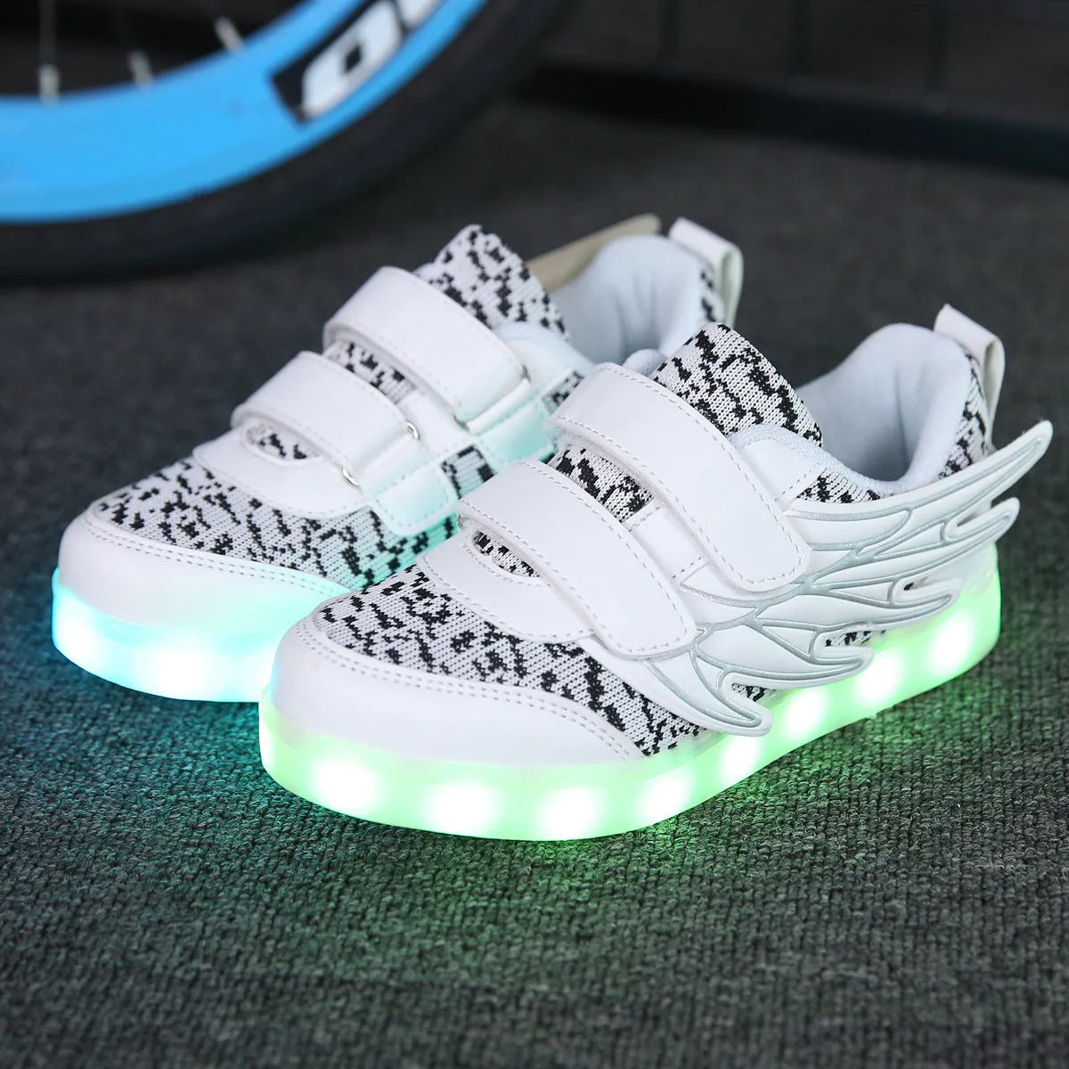 Children's plum red and white LED light up sneakers showing USB charging port and hidden mode switch.