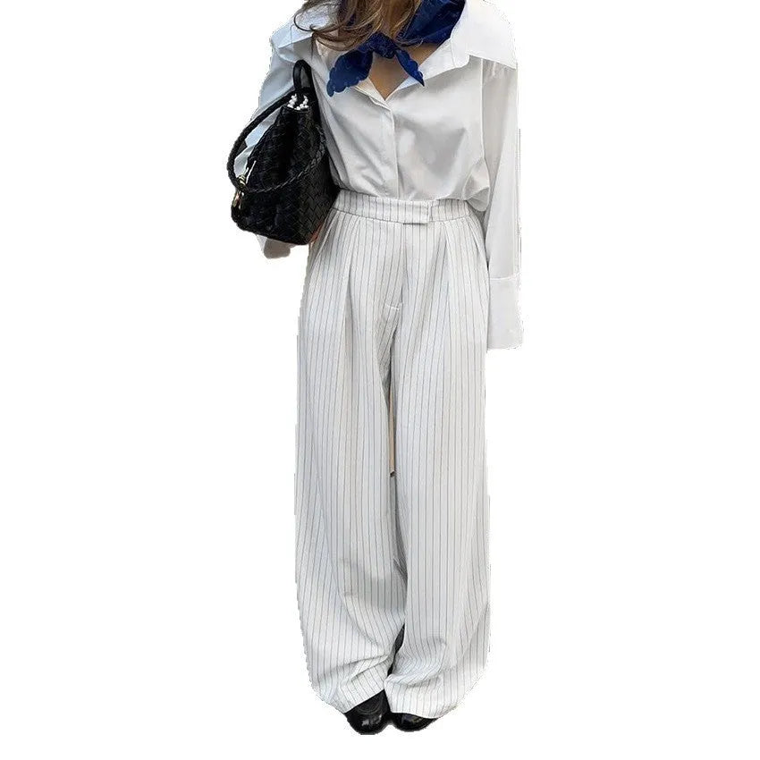 White striped wide-leg women's trousers with front zip fastening on hanger