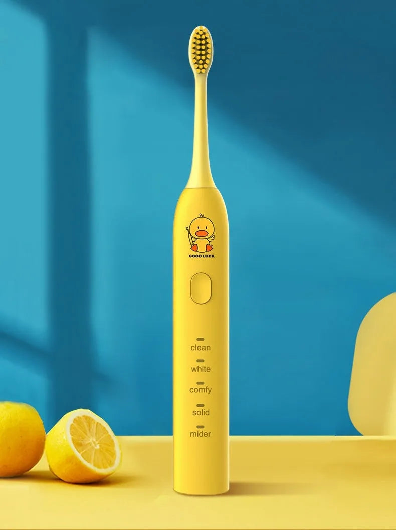 Yellow rechargeable electric toothbrush with soft bristles on a bathroom counter