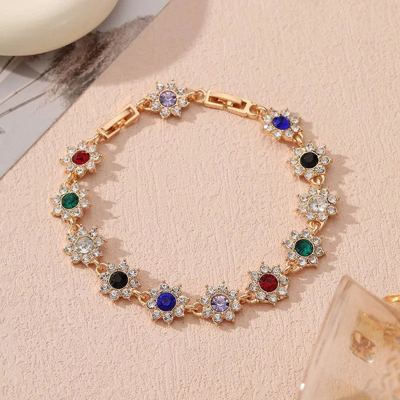 Gold and silver electroplated flower bracelets with coloured gems and crystals on a zinc alloy base.