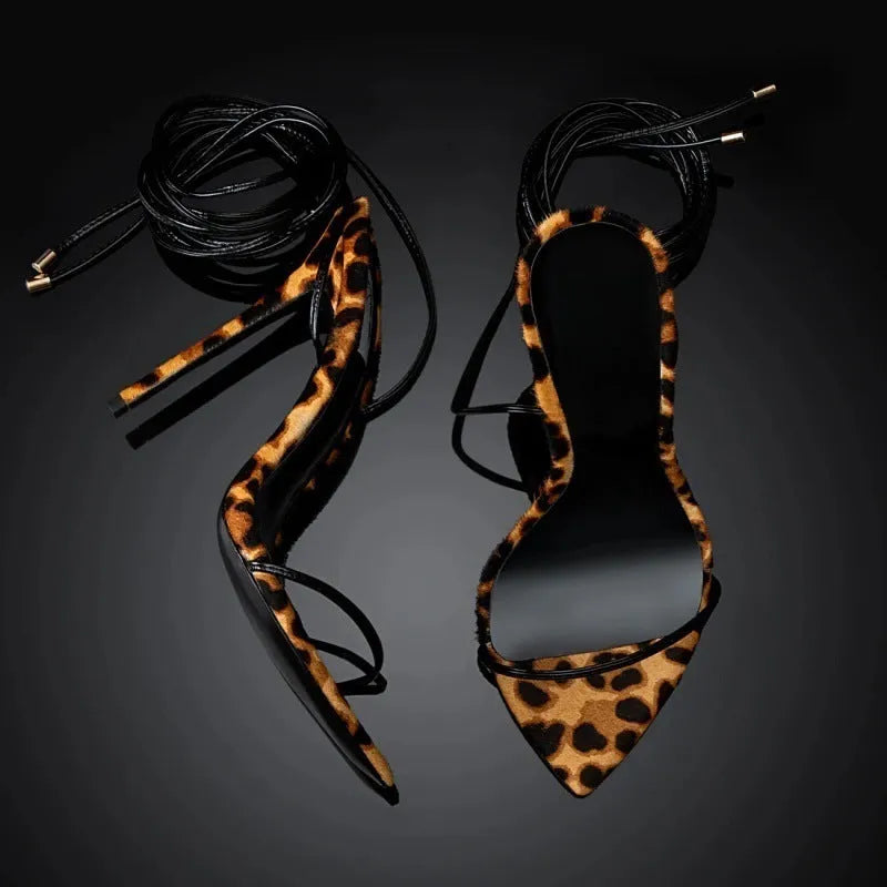 Leopard print women's gladiator sandals with pointed toe and lace-up front on a rubber sole.