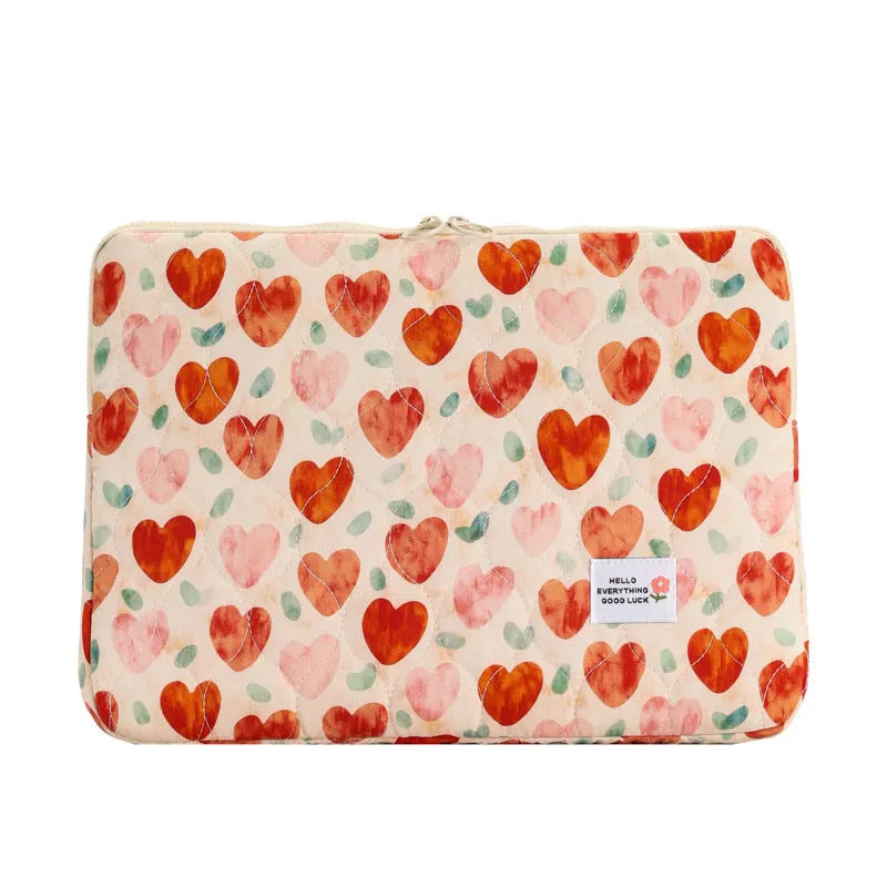 Printed cloth laptop bag showing floral and heart patterns in green, pink, and red colourways