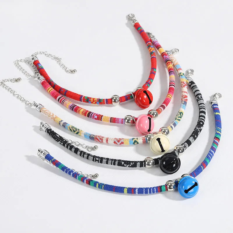 Coloured adjustable nylon pet collar with ethnic pattern, plastic quick-release buckle, and small bell.