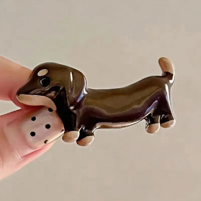 A pair of cute Dachshund dog hair barrettes with a loose, delicate design on a white background.