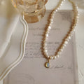 Vintage-style adjustable pearl choker necklace with a geometric alloy pendant on a silver-toned chain.