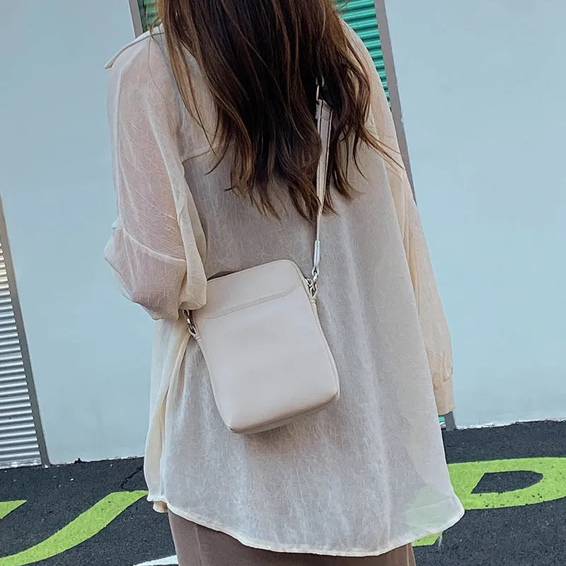 Solid colour PU leather mobile phone crossbody bag in beige showing shoulder strap and compact size