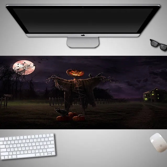 Oversized rectangular Halloween-themed mouse pad on a desk, showing one of 28 graphic designs.