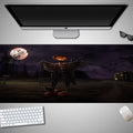 Oversized rectangular Halloween-themed mouse pad on a desk, showing one of 28 graphic designs.