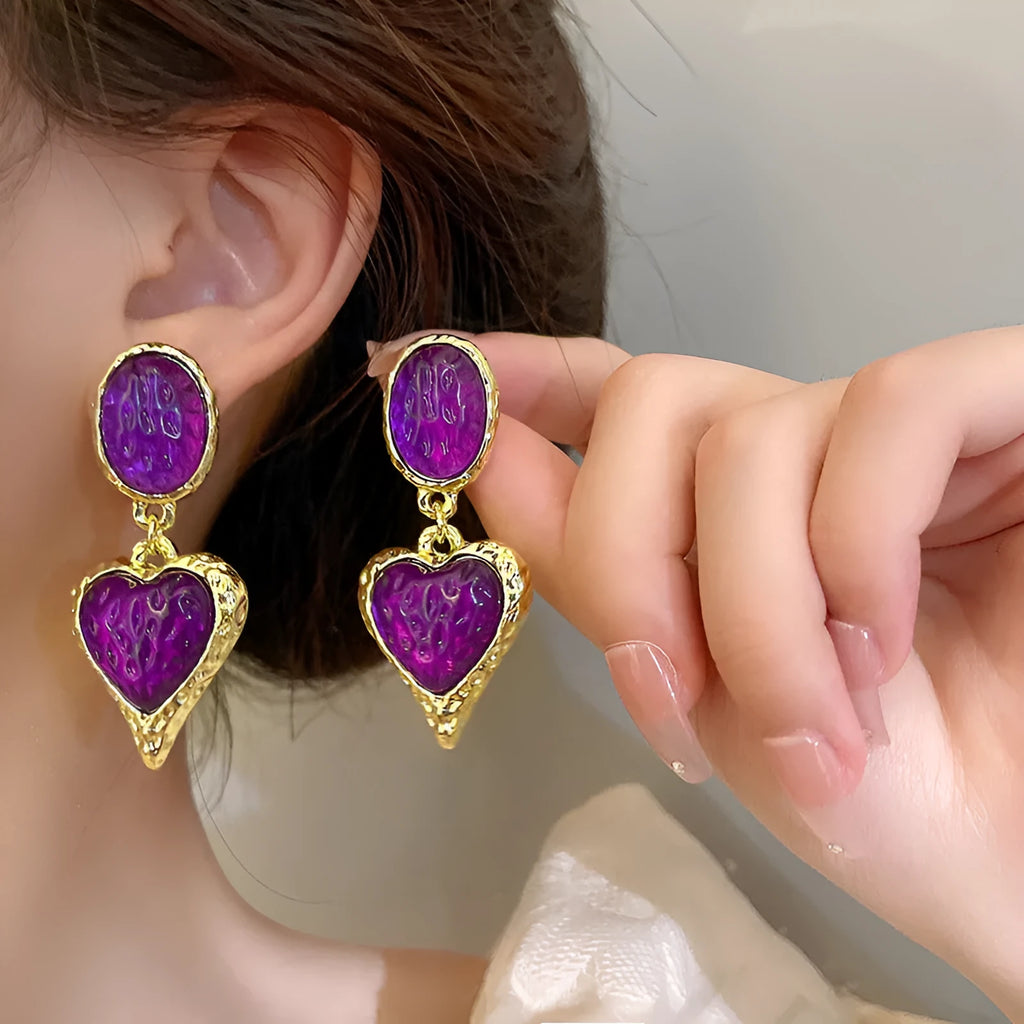 A pair of silver needle pleated oval love heart stud earrings in alloy metal, showing the textured surface and heart shape.