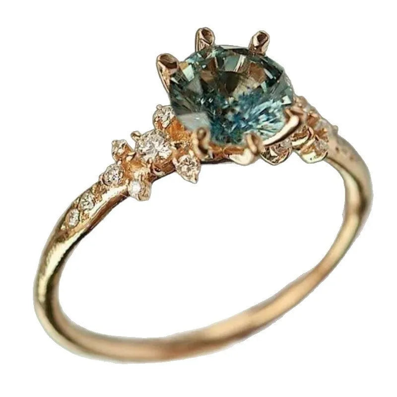 Gold plated alloy ring with geometric claw setting holding zircon stones in chamfered square pattern