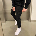 Man wearing light blue baggy polyester casual trousers with an elastic waist and patch pockets.