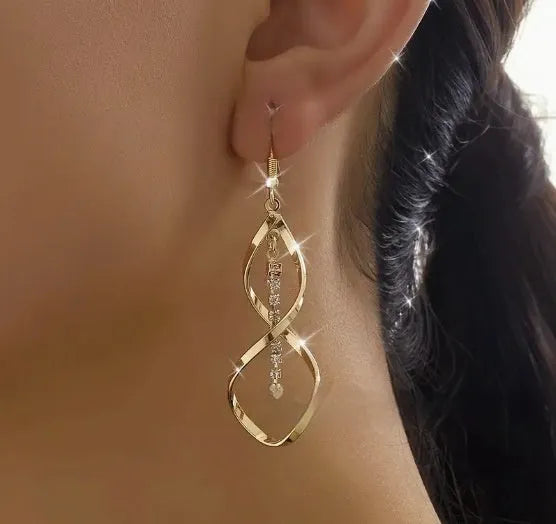 Gold colour female earrings with creative spiral design and geometric ellipse shape