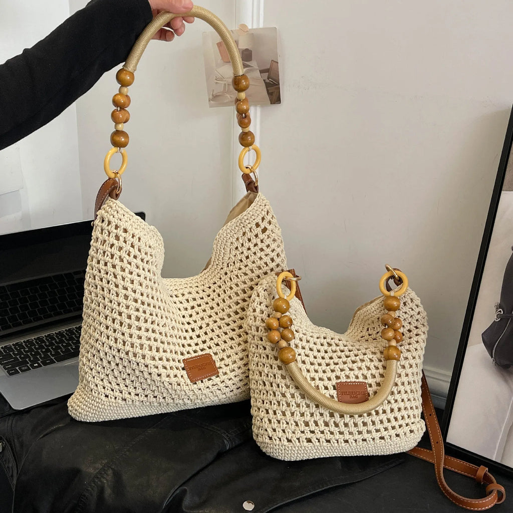Knitted crossbody tote bag in bucket shape, shown in black with contrast stitching and a zippered internal pocket.