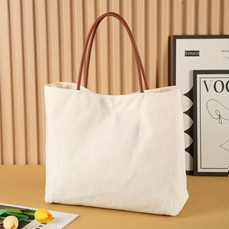 Beige white canvas tote bag with shoulder straps and front slip pockets