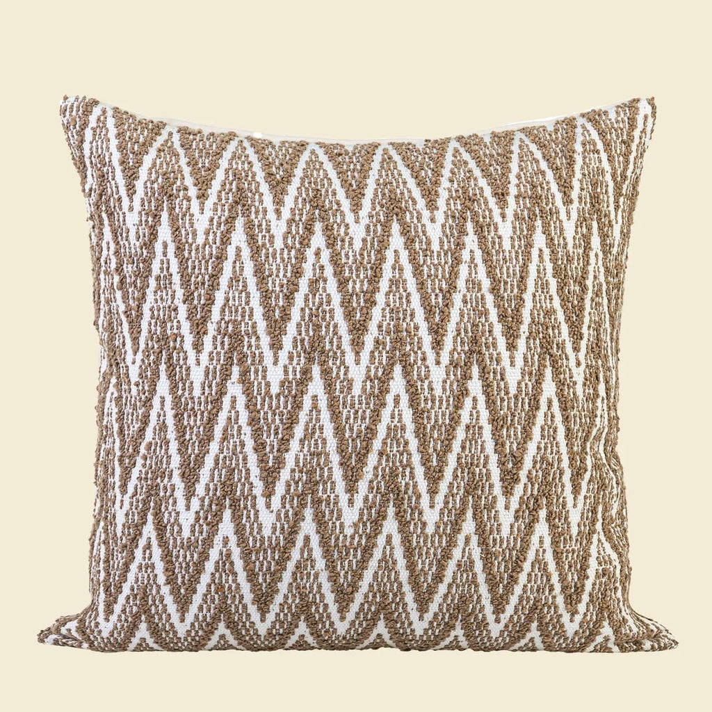 Square Chinese style cushion with geometric pattern in brown Maillard colour options on a sofa.