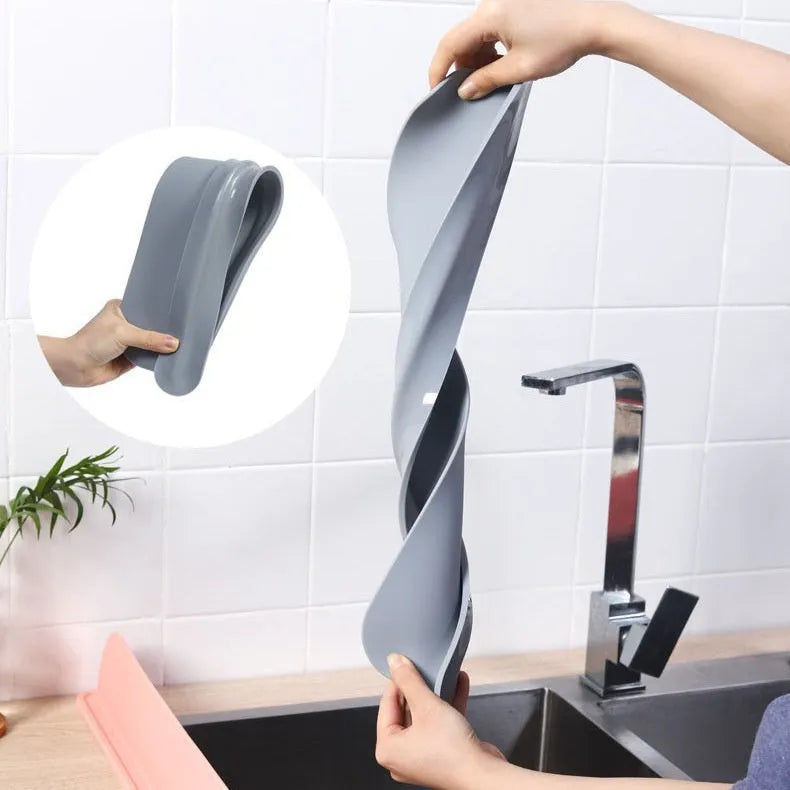 Thick grey silicone sink water blocking plate splash guard shown on a kitchen sink edge