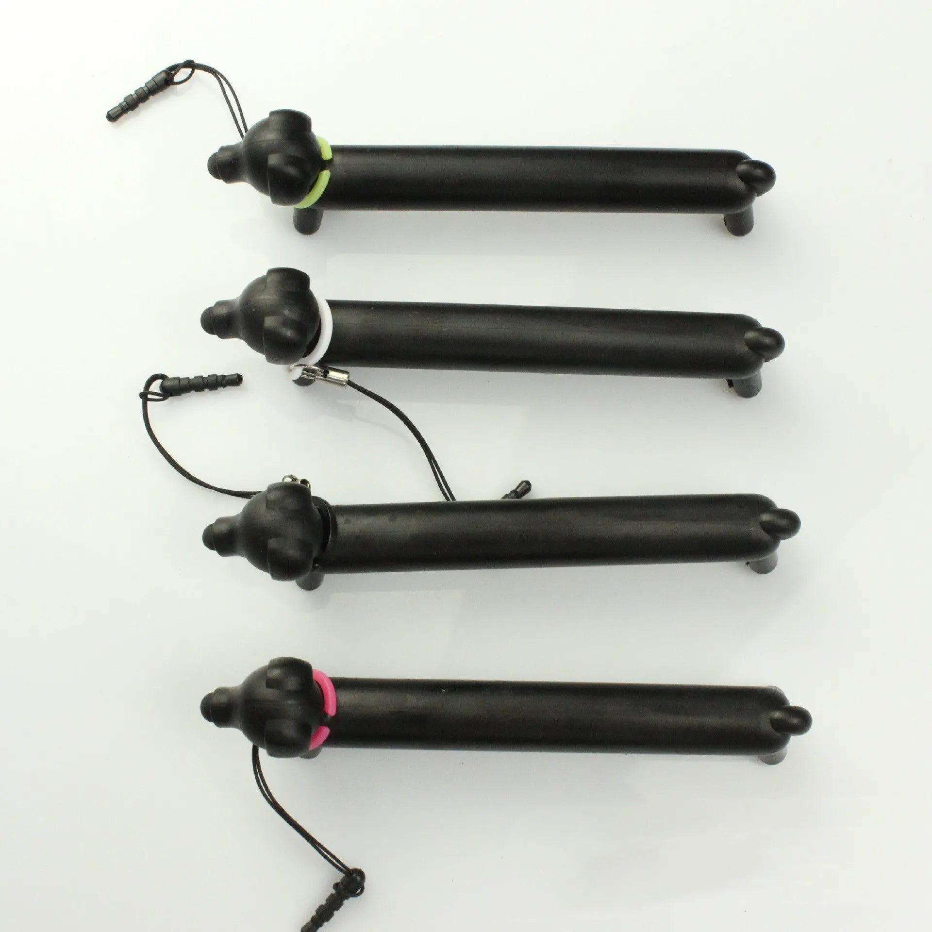 Black dog-shaped touch screen stylus pen shown next to a smartphone on a desk.