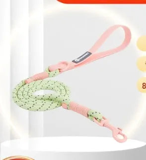 Solid colour PVC dog hand holding rope leash in dark red purple yellow on a green background.