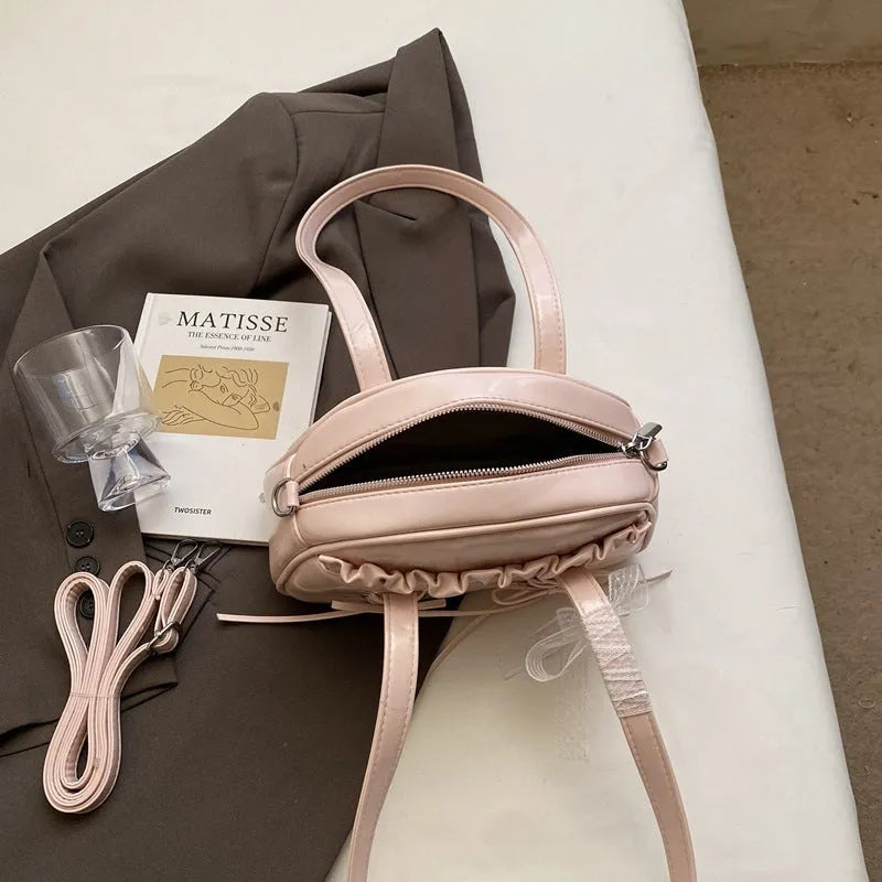 Women's bandage bow handbag in milky white colour with adjustable bow detail and internal mobile phone compartment