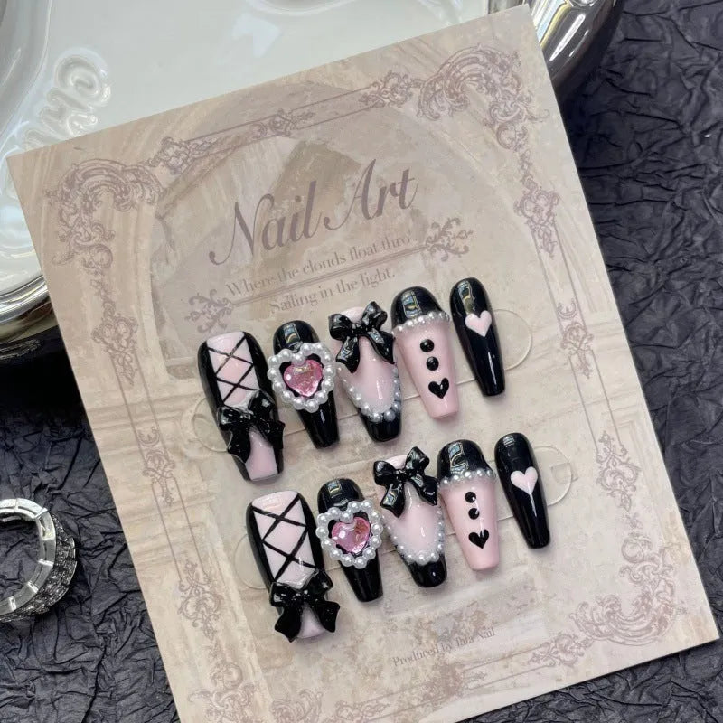 Hand-painted black and pink peach heart false nails with bow designs and cat's eye finish in four sizes
